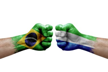 Two hands punch to each others on white background. Country flags painted fists, conflict crisis concept between brazil and sierra leone