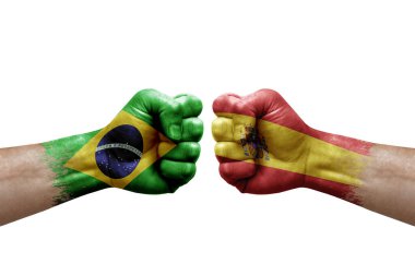 Two hands punch to each others on white background. Country flags painted fists, conflict crisis concept between brazil and spain