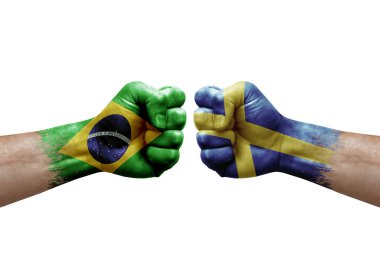 Two hands punch to each others on white background. Country flags painted fists, conflict crisis concept between brazil and sweden