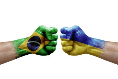 Two hands punch to each others on white background. Country flags painted fists, conflict crisis concept between brazil and ukraine