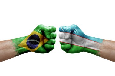 Two hands punch to each others on white background. Country flags painted fists, conflict crisis concept between brazil and uzbekistan
