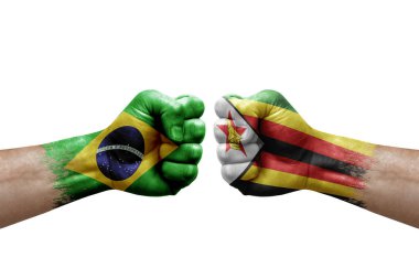Two hands punch to each others on white background. Country flags painted fists, conflict crisis concept between brazil and zimbabwe