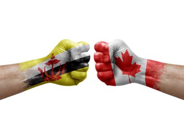 Two hands punch to each others on white background. Country flags painted fists, conflict crisis concept between brunei and canada