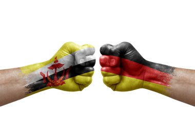 Two hands punch to each others on white background. Country flags painted fists, conflict crisis concept between brunei and germany