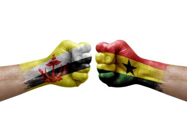 Two hands punch to each others on white background. Country flags painted fists, conflict crisis concept between brunei and ghana