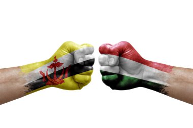 Two hands punch to each others on white background. Country flags painted fists, conflict crisis concept between brunei and hungary