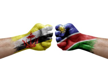 Two hands punch to each others on white background. Country flags painted fists, conflict crisis concept between brunei and namibia