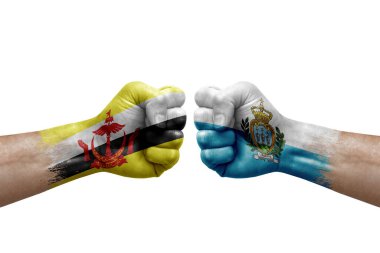 Two hands punch to each others on white background. Country flags painted fists, conflict crisis concept between brunei and san marino