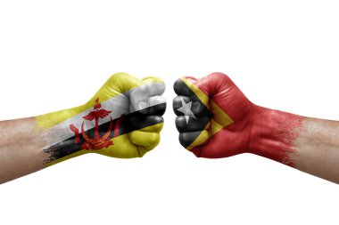 Two hands punch to each others on white background. Country flags painted fists, conflict crisis concept between brunei and timor leste