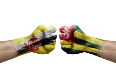 Two hands punch to each others on white background. Country flags painted fists, conflict crisis concept between brunei and togo