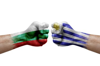 Two hands punch to each others on white background. Country flags painted fists, conflict crisis concept between bulgaria and uruguay