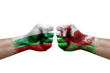 Two hands punch to each others on white background. Country flags painted fists, conflict crisis concept between bulgaria and wales