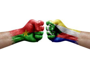 Two hands punch to each others on white background. Country flags painted fists, conflict crisis concept between burkina faso and comoros