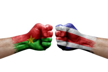 Two hands punch to each others on white background. Country flags painted fists, conflict crisis concept between burkina faso and costa rica