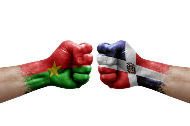 Two hands punch to each others on white background. Country flags painted fists, conflict crisis concept between burkina faso and dominican republic