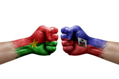 Two hands punch to each others on white background. Country flags painted fists, conflict crisis concept between burkina faso and haiti