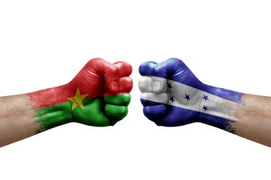 Two hands punch to each others on white background. Country flags painted fists, conflict crisis concept between burkina faso and honduras