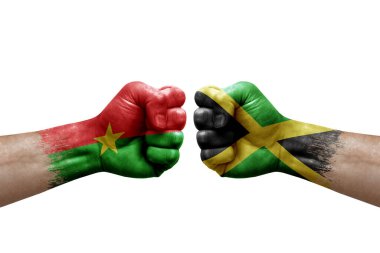Two hands punch to each others on white background. Country flags painted fists, conflict crisis concept between burkina faso and jamaica