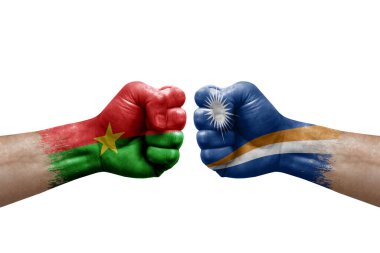 Two hands punch to each others on white background. Country flags painted fists, conflict crisis concept between burkina faso and marshall islands