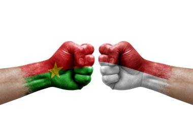 Two hands punch to each others on white background. Country flags painted fists, conflict crisis concept between burkina faso and monaco