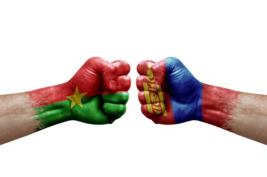 Two hands punch to each others on white background. Country flags painted fists, conflict crisis concept between burkina faso and mongolia