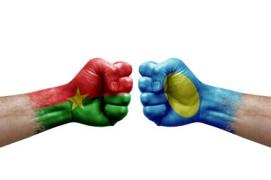 Two hands punch to each others on white background. Country flags painted fists, conflict crisis concept between burkina faso and palau