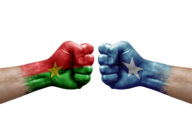 Two hands punch to each others on white background. Country flags painted fists, conflict crisis concept between burkina faso and somalia