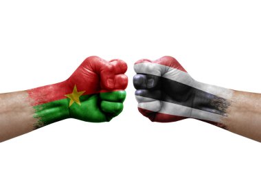 Two hands punch to each others on white background. Country flags painted fists, conflict crisis concept between burkina faso and thailand