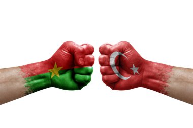 Two hands punch to each others on white background. Country flags painted fists, conflict crisis concept between burkina faso and turkey