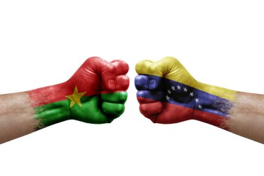 Two hands punch to each others on white background. Country flags painted fists, conflict crisis concept between burkina faso and venezuela