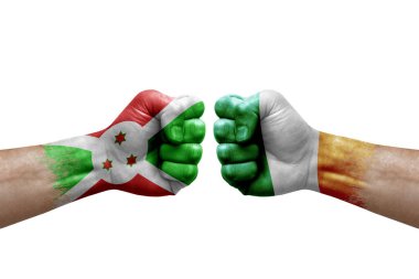 Two hands punch to each others on white background. Country flags painted fists, conflict crisis concept between burundi and ireland