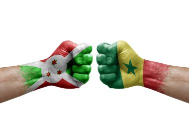 Two hands punch to each others on white background. Country flags painted fists, conflict crisis concept between burundi and senegal
