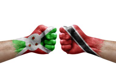 Two hands punch to each others on white background. Country flags painted fists, conflict crisis concept between burundi and tobago