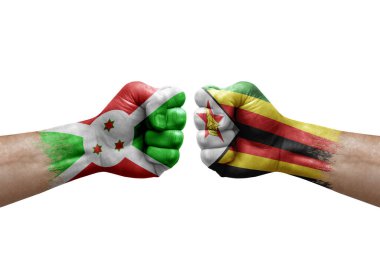 Two hands punch to each others on white background. Country flags painted fists, conflict crisis concept between burundi and zimbabwe