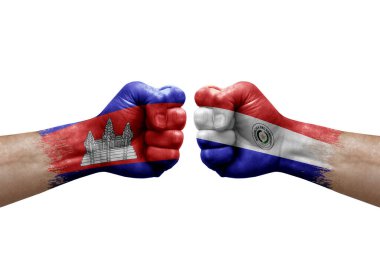 Two hands punch to each others on white background. Country flags painted fists, conflict crisis concept between cambodia and paraguay