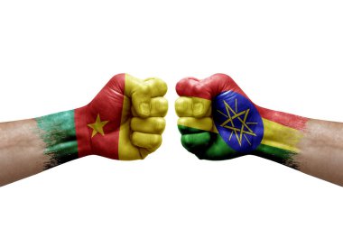 Two hands punch to each others on white background. Country flags painted fists, conflict crisis concept between cameroon and ethiopia