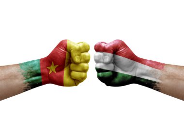 Two hands punch to each others on white background. Country flags painted fists, conflict crisis concept between cameroon and hungary