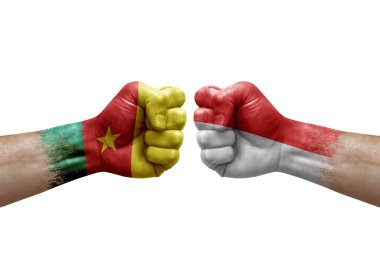 Two hands punch to each others on white background. Country flags painted fists, conflict crisis concept between cameroon and indonesia