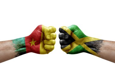 Two hands punch to each others on white background. Country flags painted fists, conflict crisis concept between cameroon and jamaica