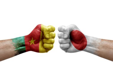 Two hands punch to each others on white background. Country flags painted fists, conflict crisis concept between cameroon and japan