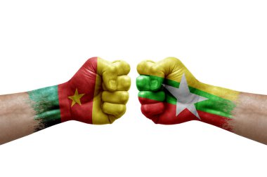 Two hands punch to each others on white background. Country flags painted fists, conflict crisis concept between cameroon and myanmar