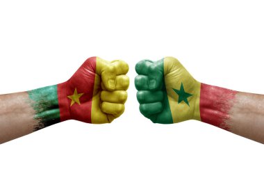 Two hands punch to each others on white background. Country flags painted fists, conflict crisis concept between cameroon and senegal