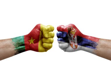 Two hands punch to each others on white background. Country flags painted fists, conflict crisis concept between cameroon and serbia