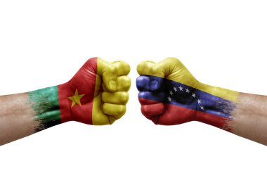 Two hands punch to each others on white background. Country flags painted fists, conflict crisis concept between cameroon and venezuela