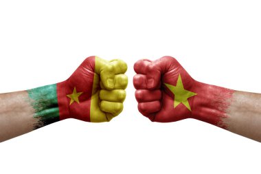 Two hands punch to each others on white background. Country flags painted fists, conflict crisis concept between cameroon and vietnam