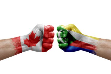 Two hands punch to each others on white background. Country flags painted fists, conflict crisis concept between canada and comoros