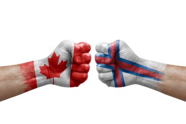 Two hands punch to each others on white background. Country flags painted fists, conflict crisis concept between canada and faroe islands
