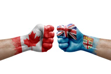 Two hands punch to each others on white background. Country flags painted fists, conflict crisis concept between canada and fiji