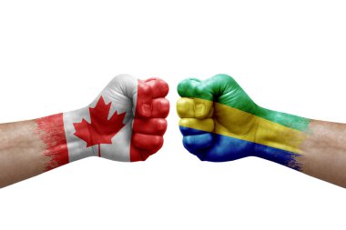 Two hands punch to each others on white background. Country flags painted fists, conflict crisis concept between canada and gabon