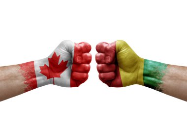 Two hands punch to each others on white background. Country flags painted fists, conflict crisis concept between canada and guinea